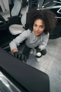 Auto detailer cleaning a car door